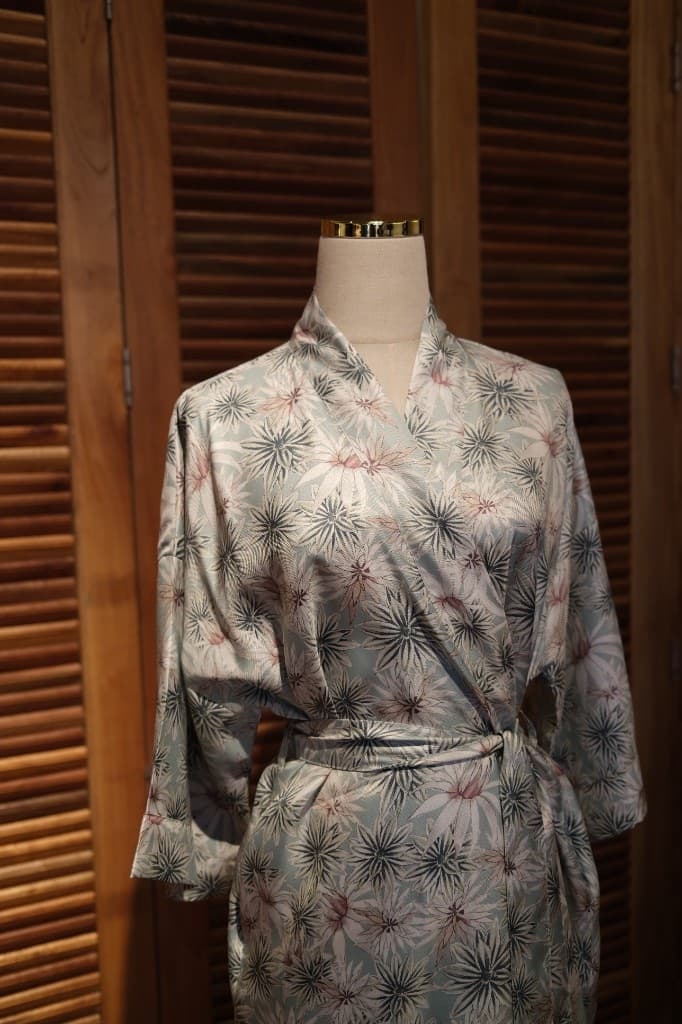 Silk kimono-style wrap dress with floral starburst pattern in mint blue and teal