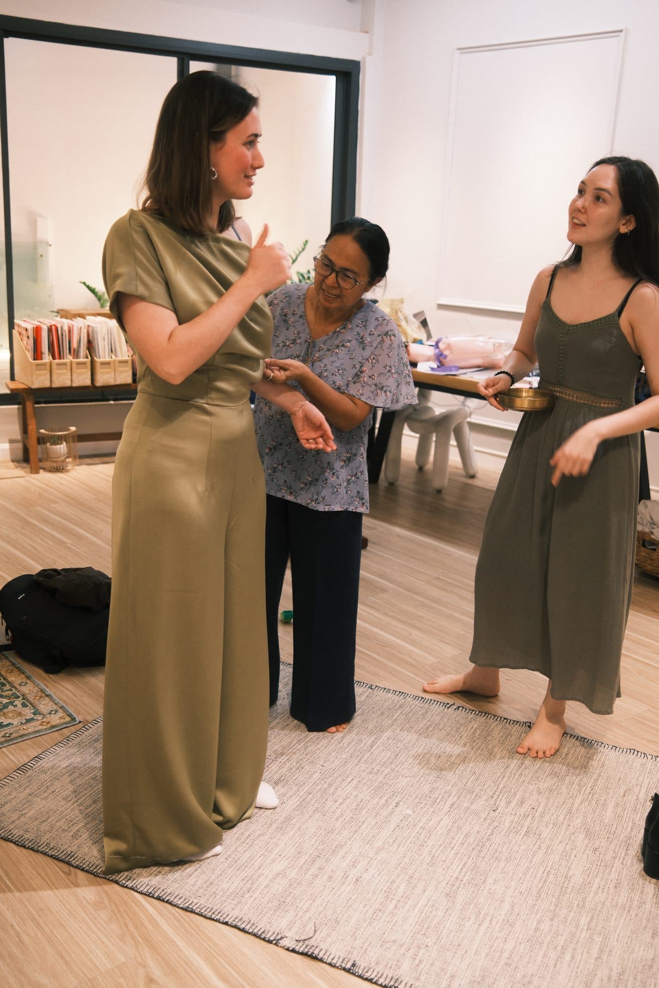 A LALEDA tailor pinning a client's dress during a fitting at the atelier