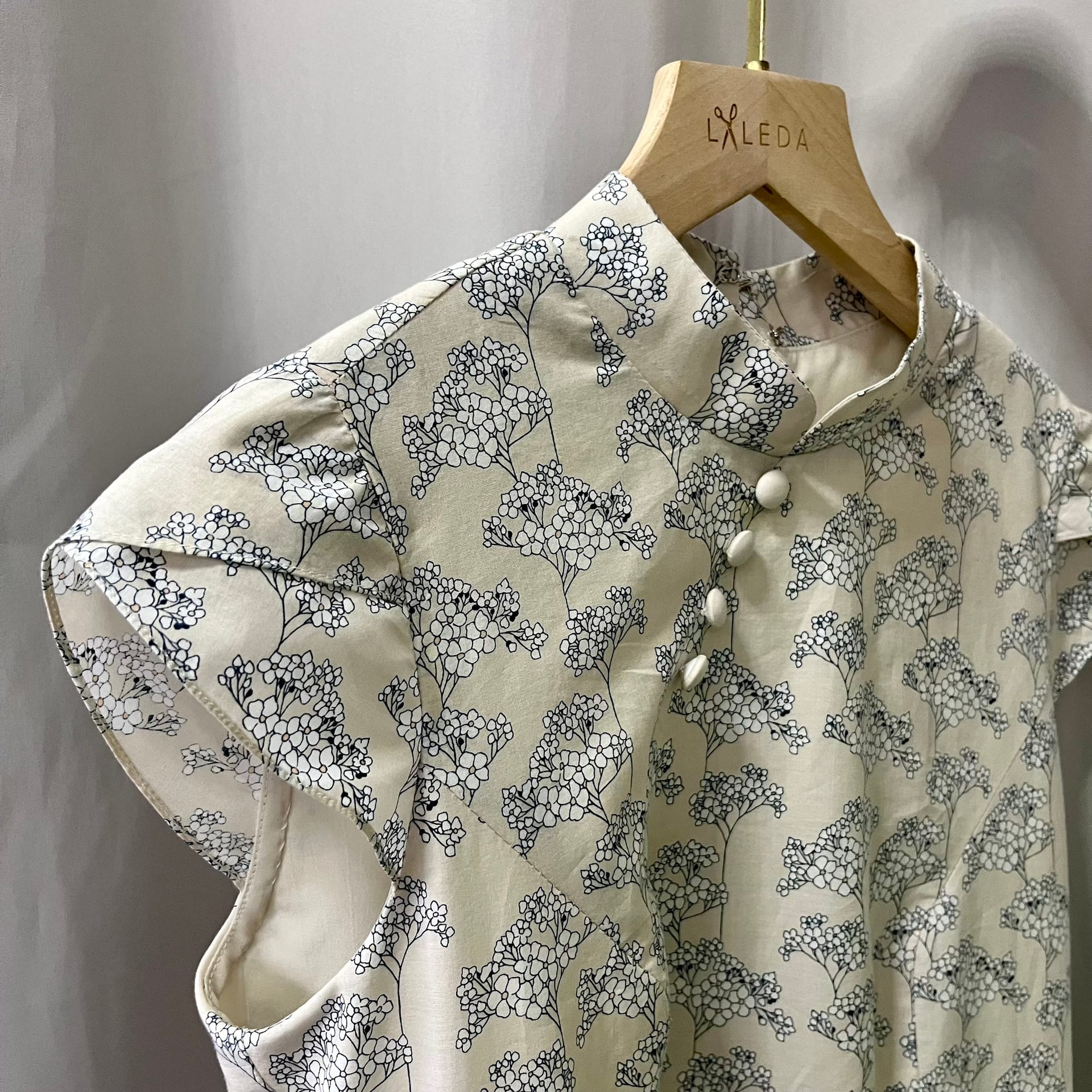 Cream beige blouse with a black floral print design