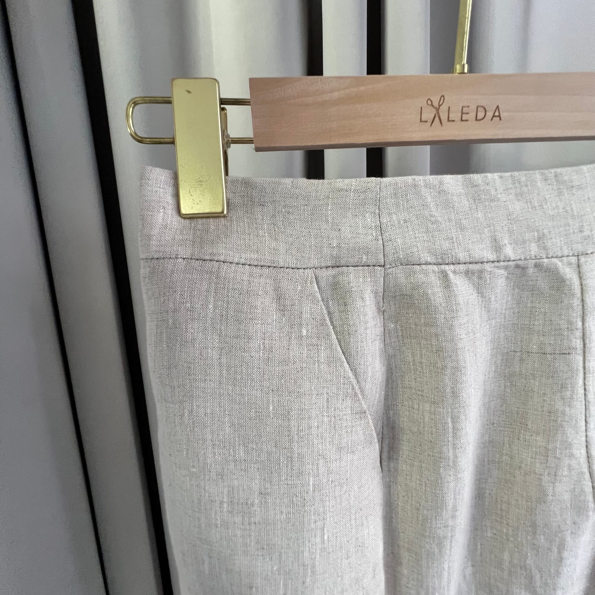 Light grey linen trousers waist and dart detail on a LALEDA hanger