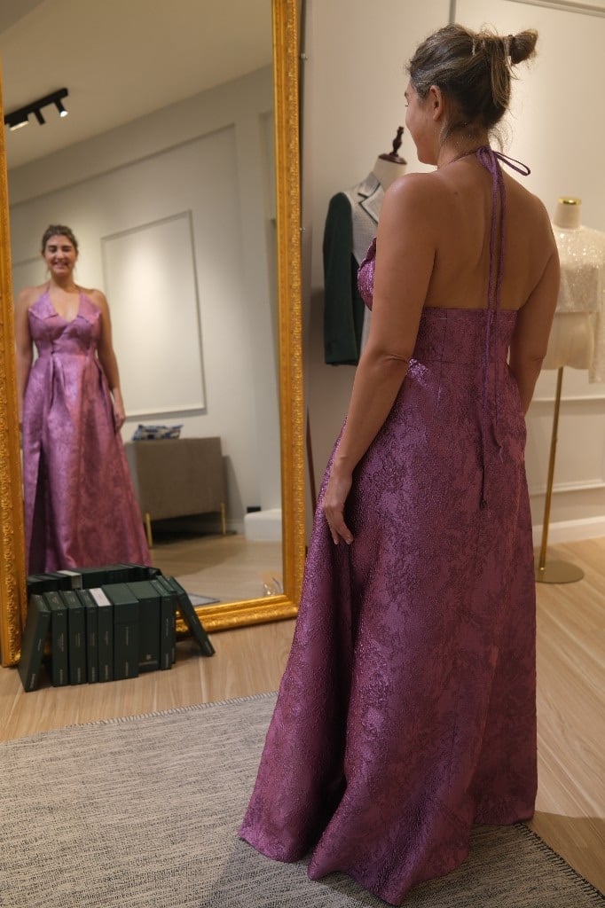 Magenta brocade halter gown at fitting in front of a mirror