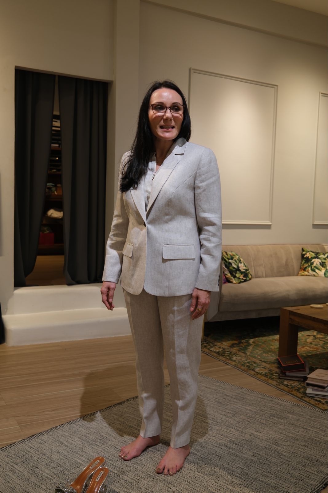 Client in a light grey linen women's suit during fitting at LALEDA atelier