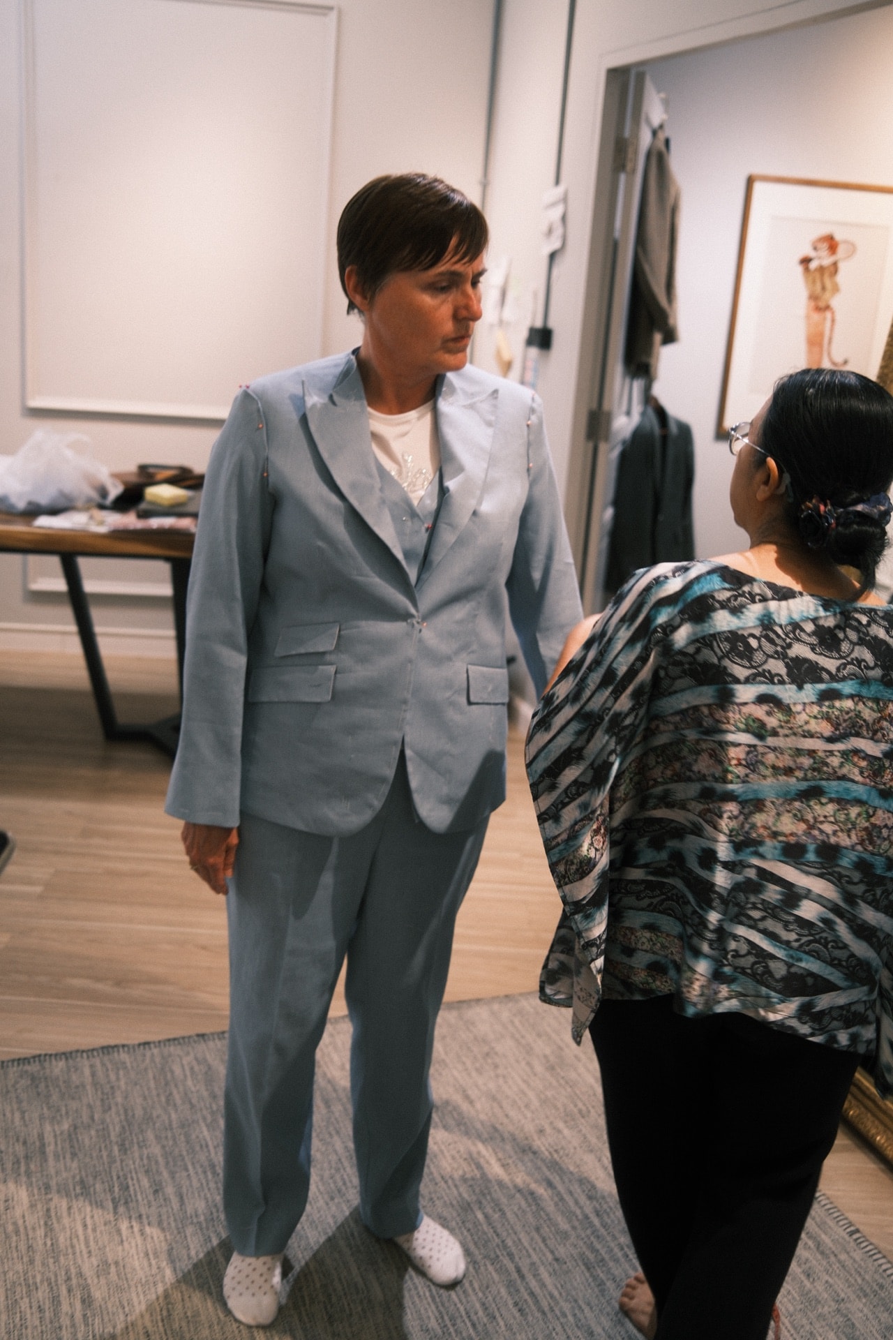 LALEDA tailor adjusting the fit of a baby blue linen blazer on a customer