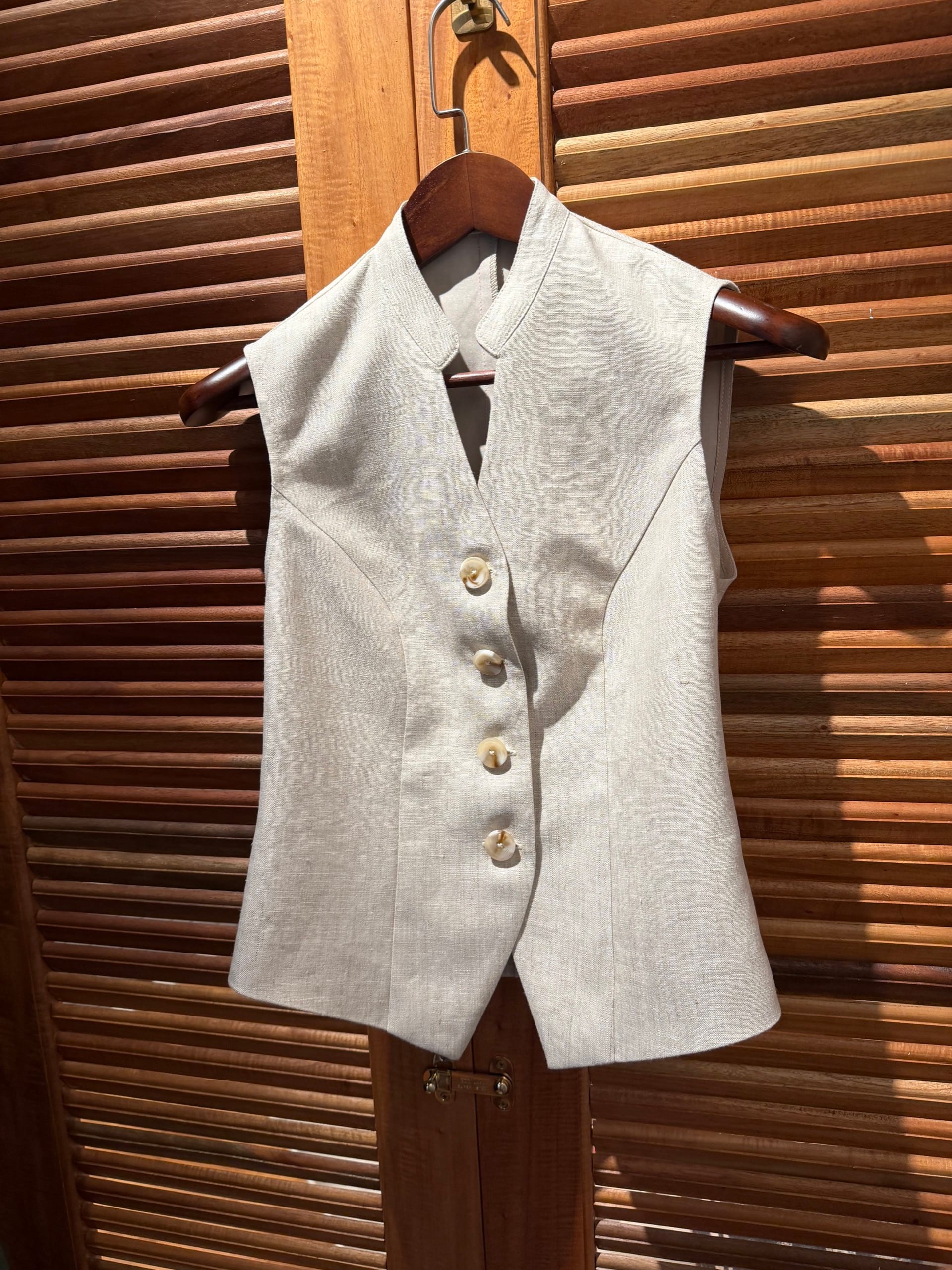 Beige linen vest with four buttons, sleeveless