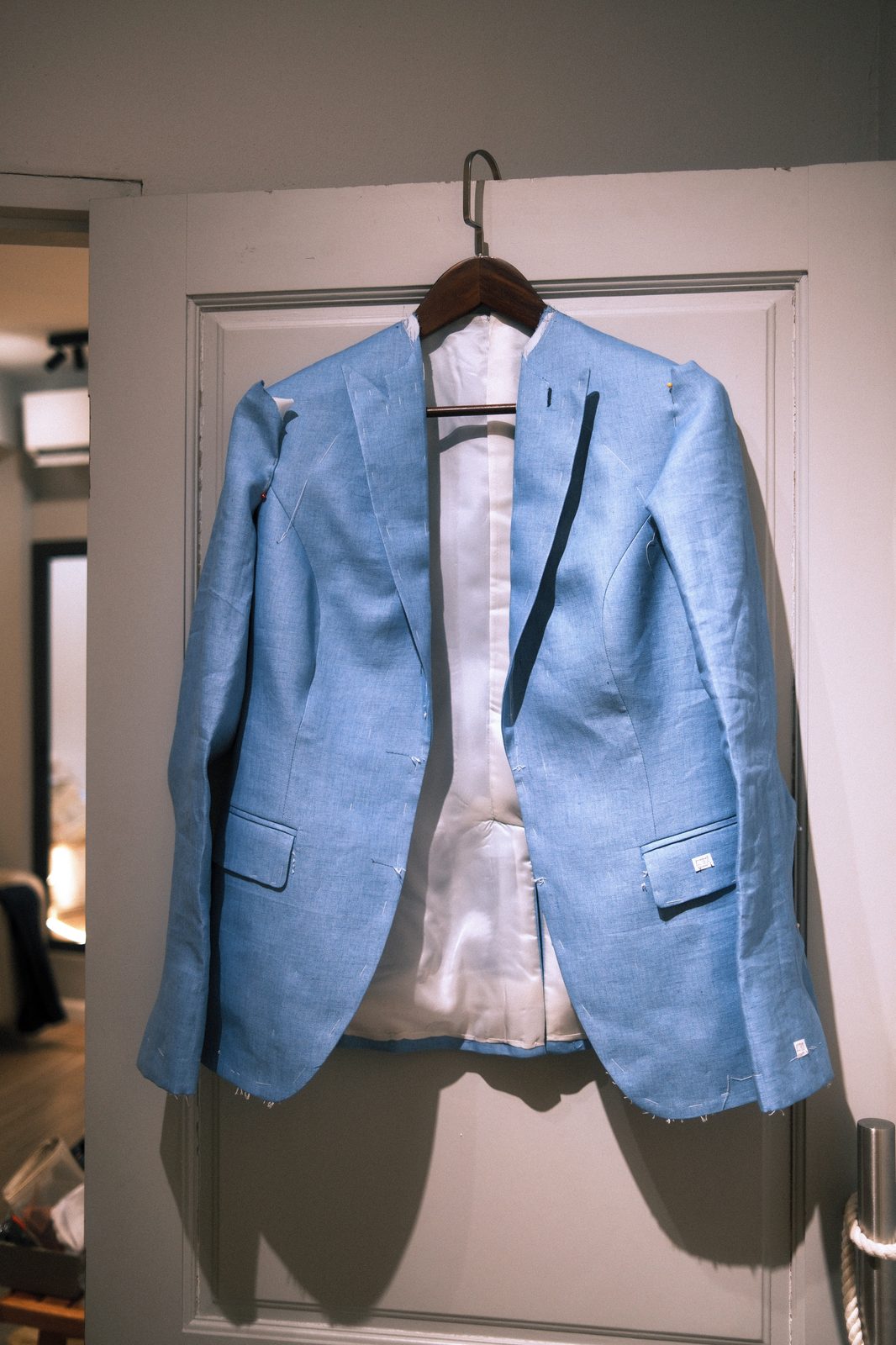 Light blue linen women's blazer on a hanger ready for fitting at LALEDA