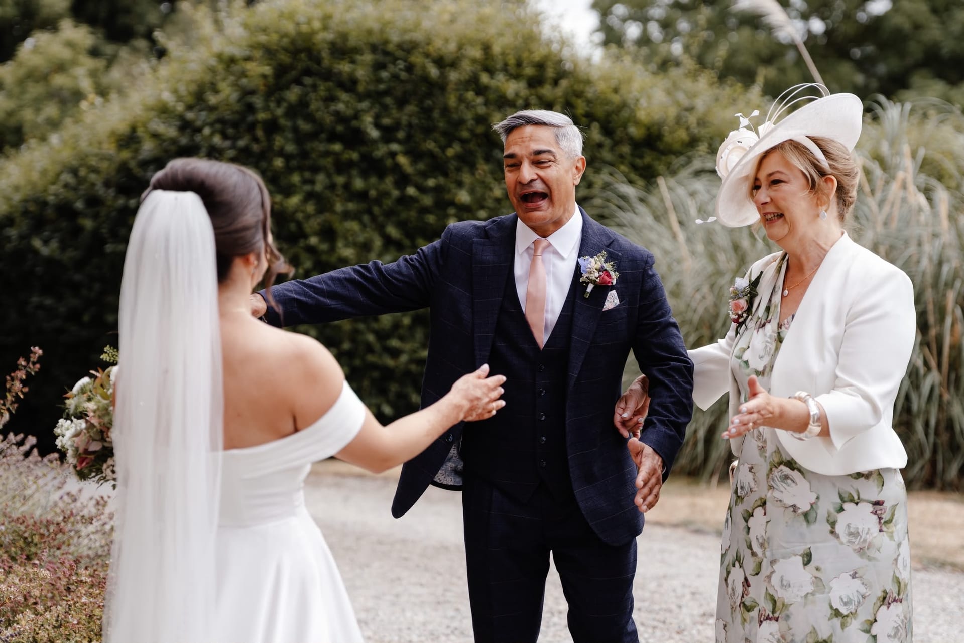 The bride's parents greeting her in the garden before the wedding reception