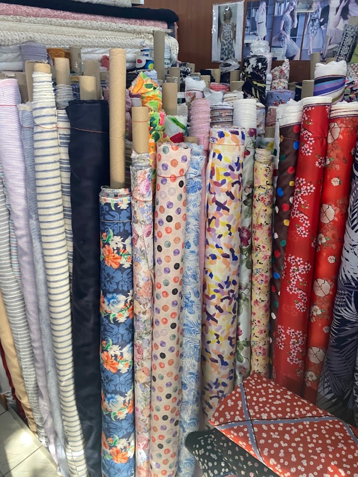 Rolls of floral and patterned fabric standing at Brooke's Fabrics, Bangkok