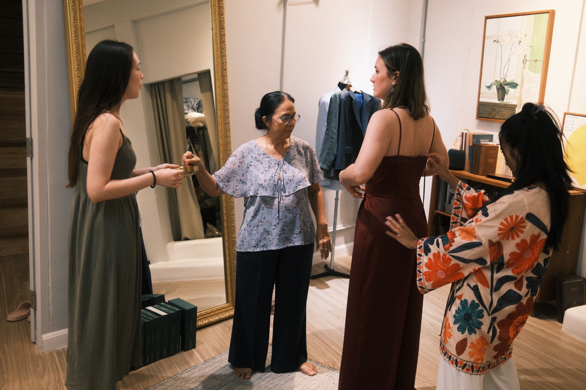LALEDA team fitting a customer in a burgundy jumpsuit at the atelier mirror