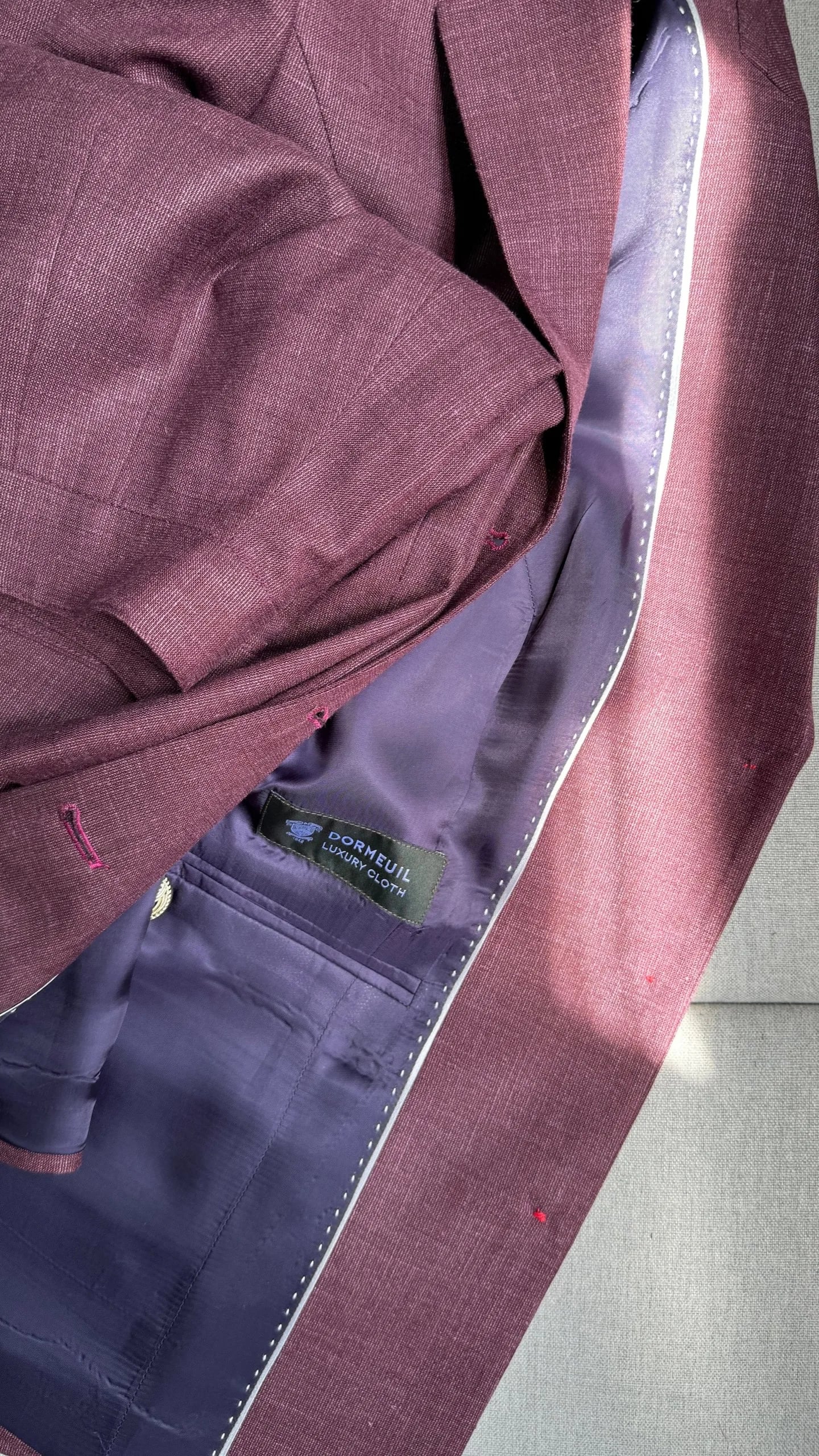 Inside of a burgundy suit jacket showing premium lining at LALEDA