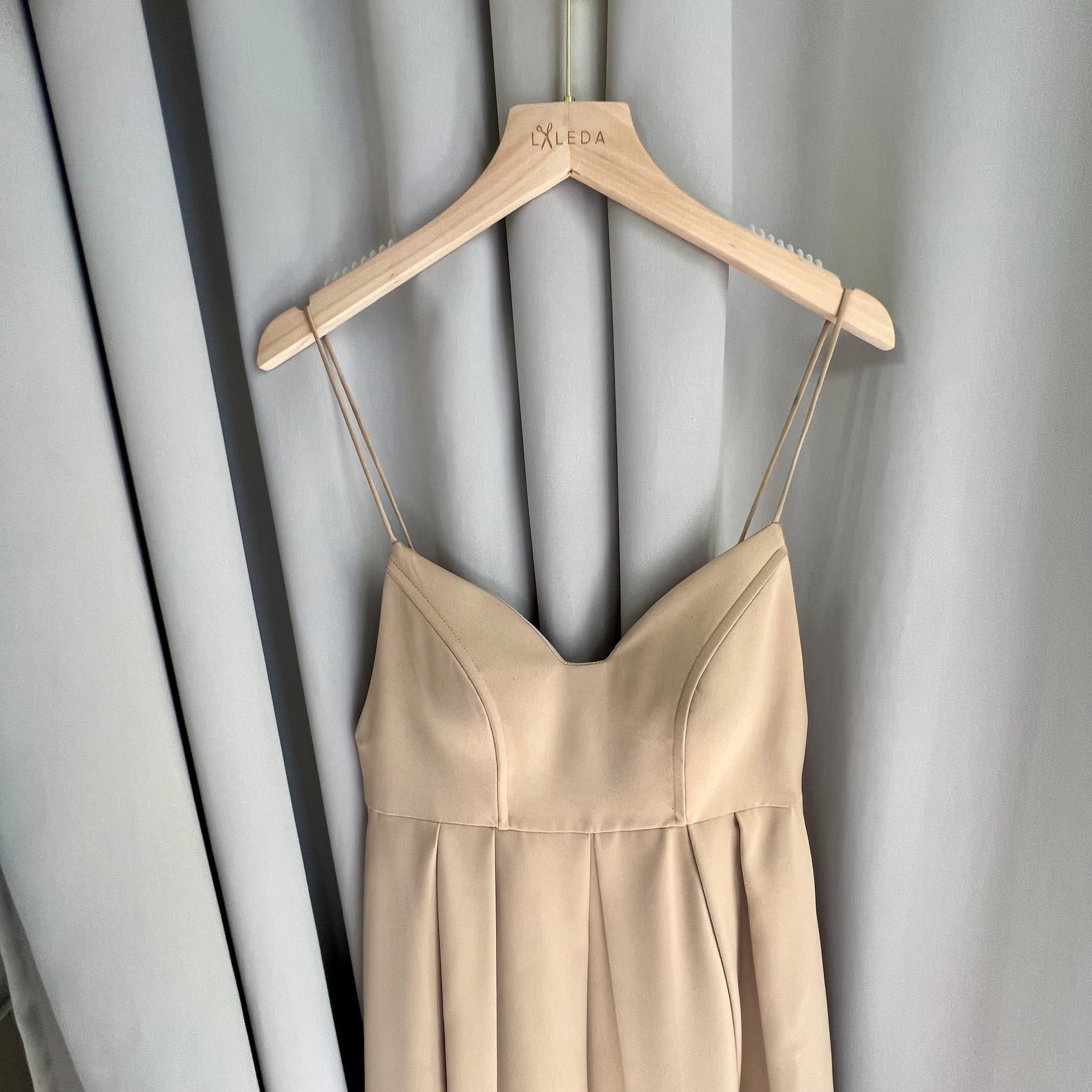 Cream summer dress with thin straps and gathered waist on a LALEDA hanger