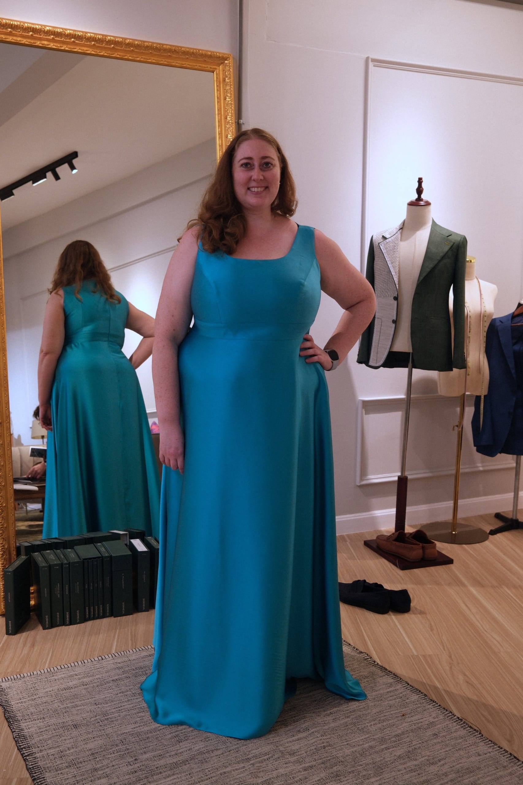 Customer in a tailored teal blue evening gown at the atelier