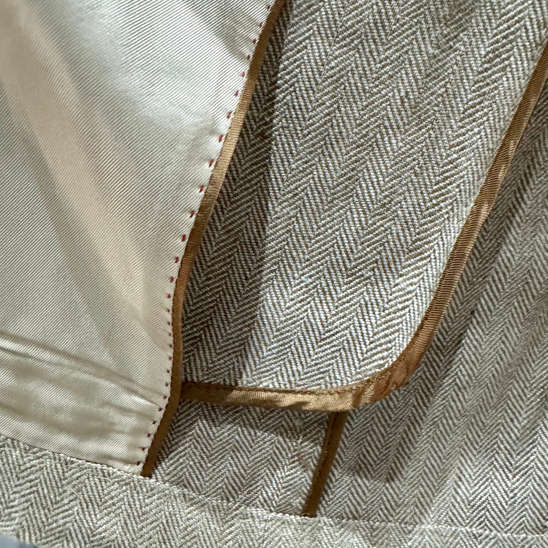 Grey herringbone women's suit with lining detail visible