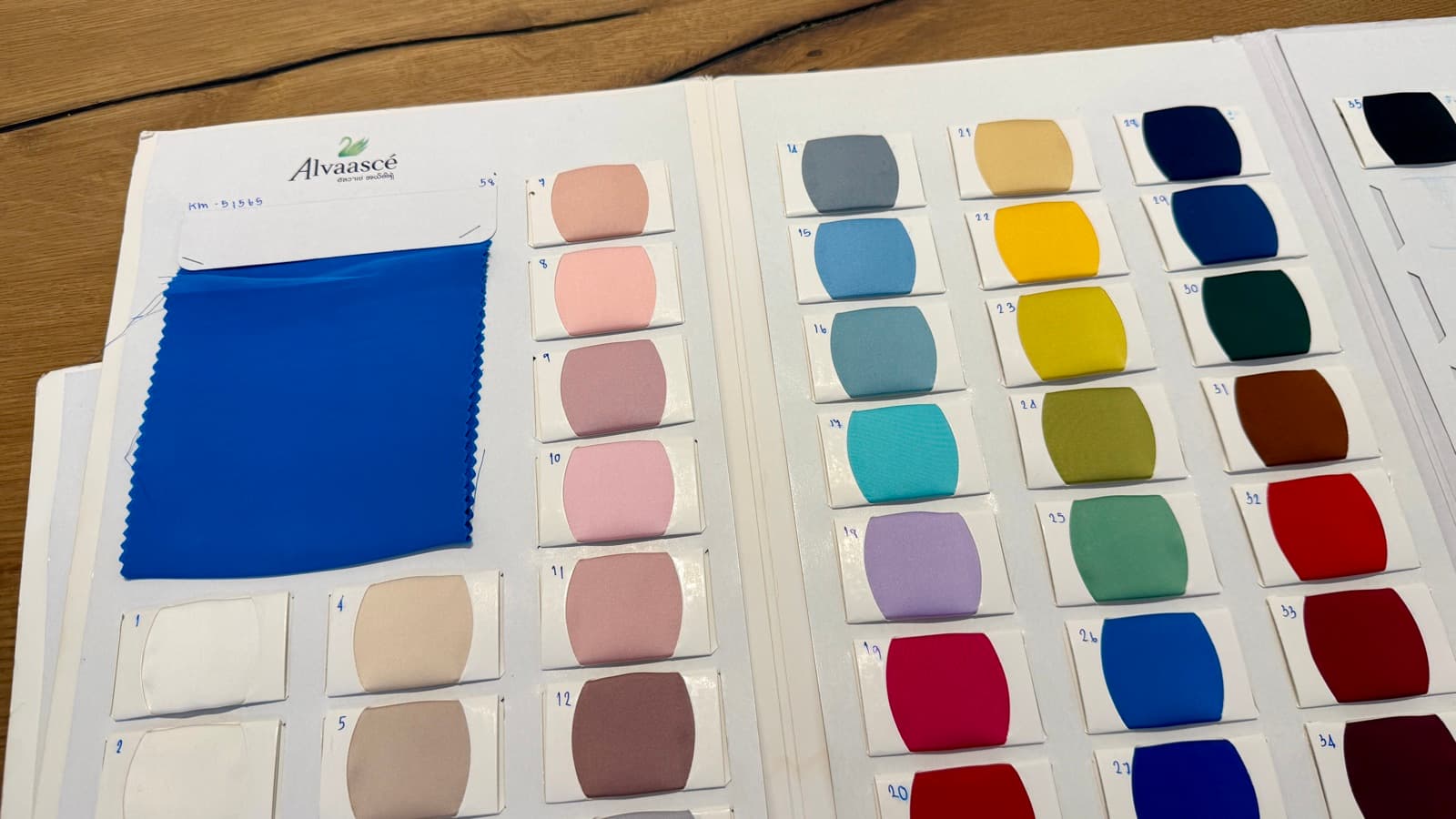 Izabella silky satin colour swatch book, with a blue fabric sample and numbered shades