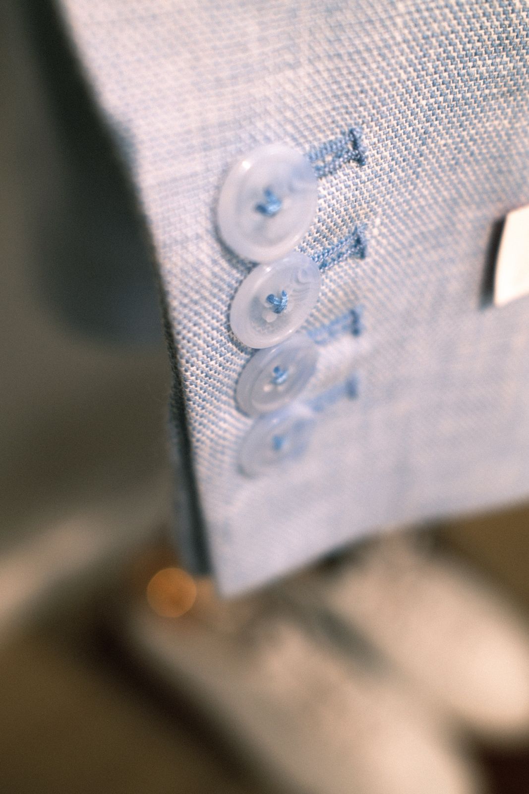 Close-up of working sleeve buttons on a light blue linen jacket at LALEDA