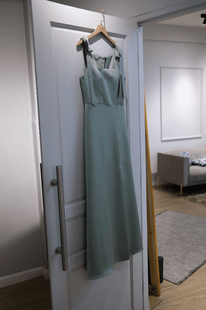 Light sage green maxi dress with square neckline and bow straps on hanger