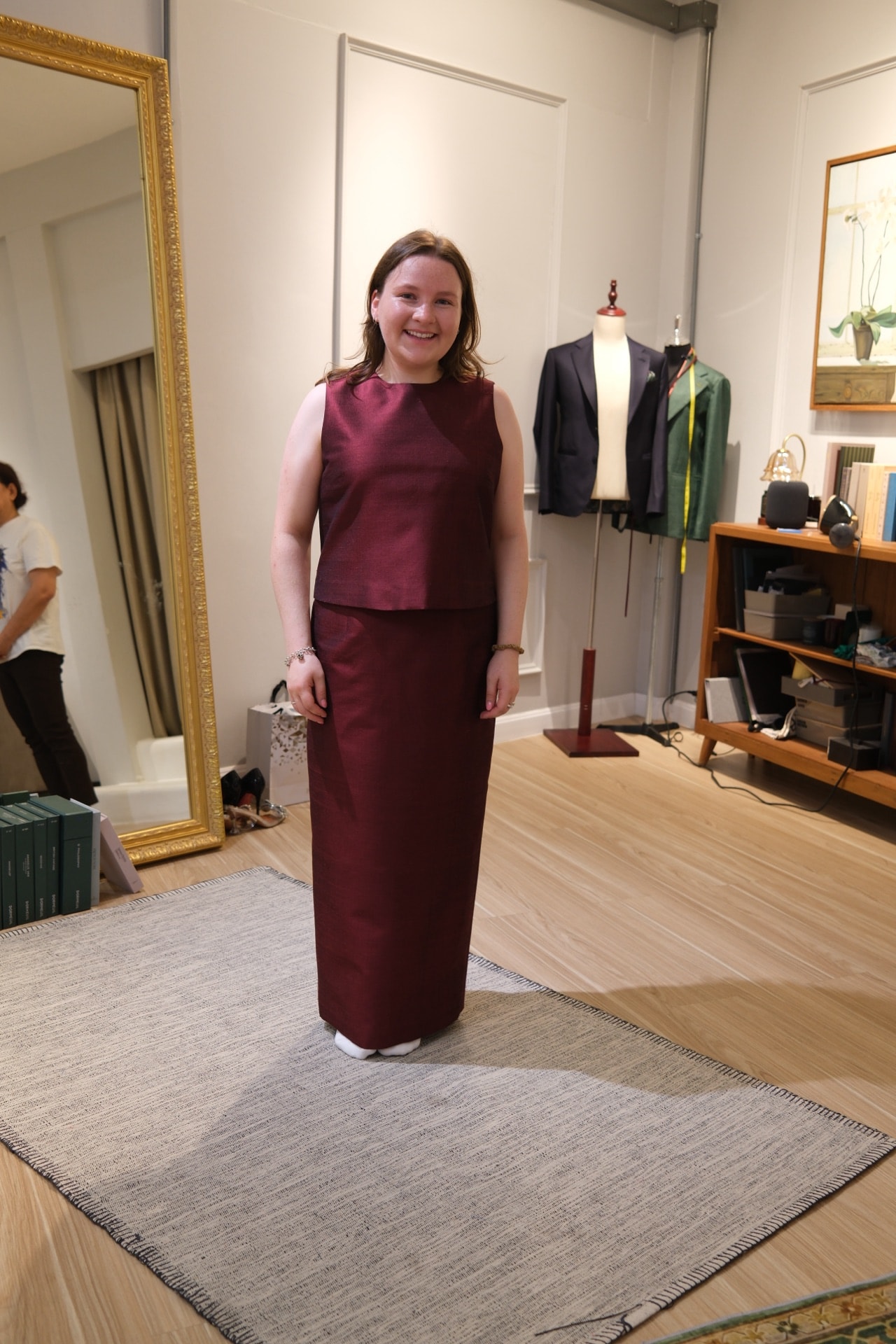 Customer in a custom maroon Thai silk dress at the atelier