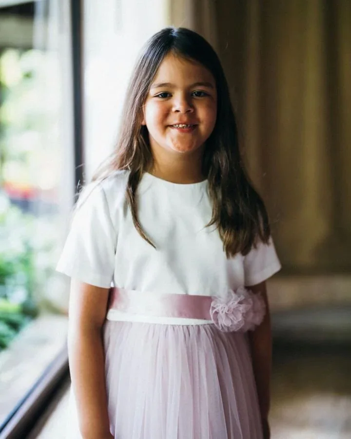 Young flower girl in a soft lilac tulle skirt holding a flower basket