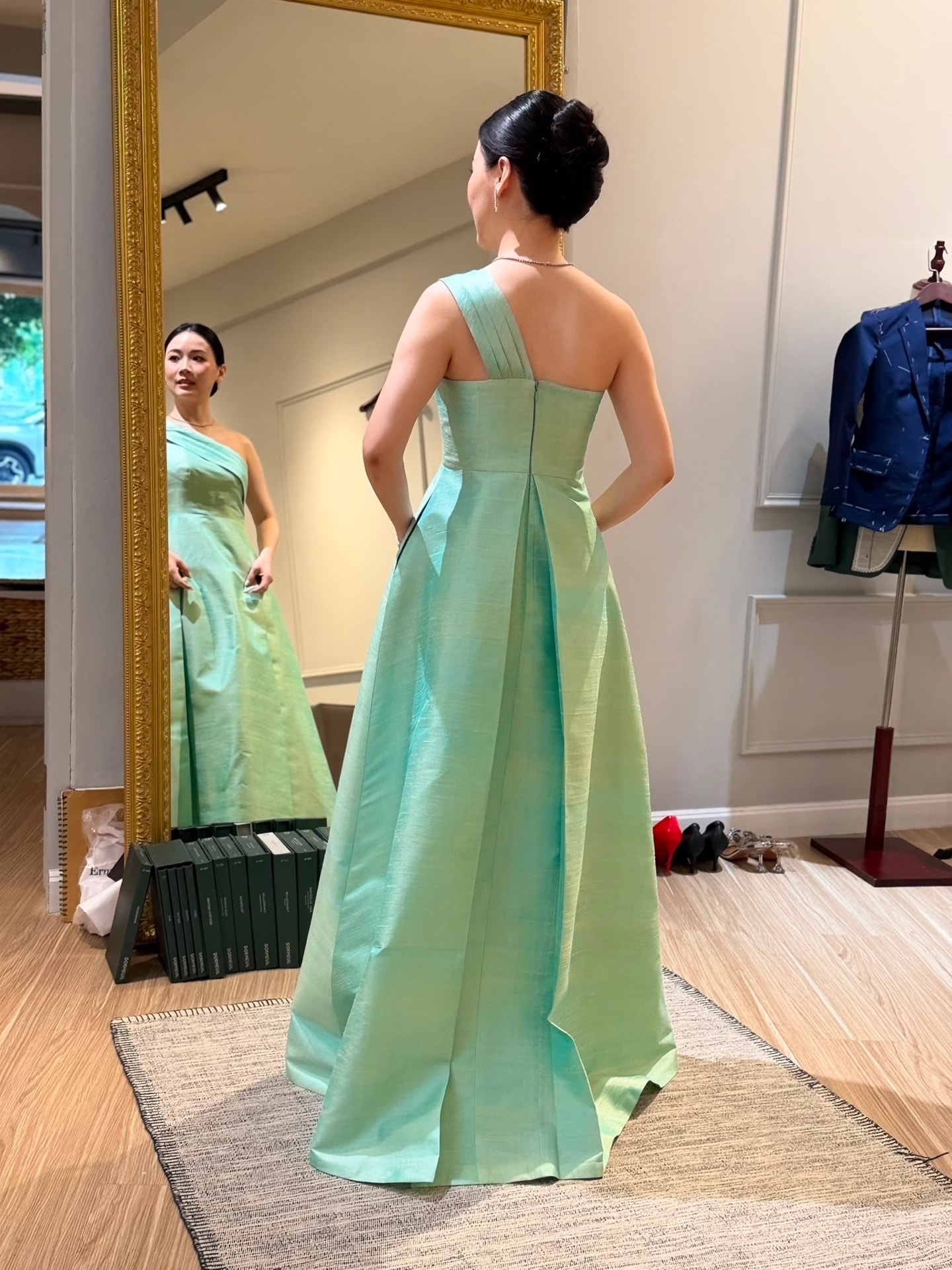 Client in a mint silk one-shoulder gown during mirror fitting at LALEDA