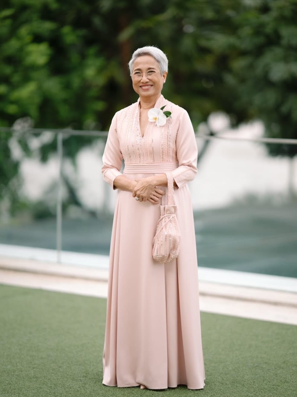 Mother of the bride in a custom blush gown with beaded bodice, full length