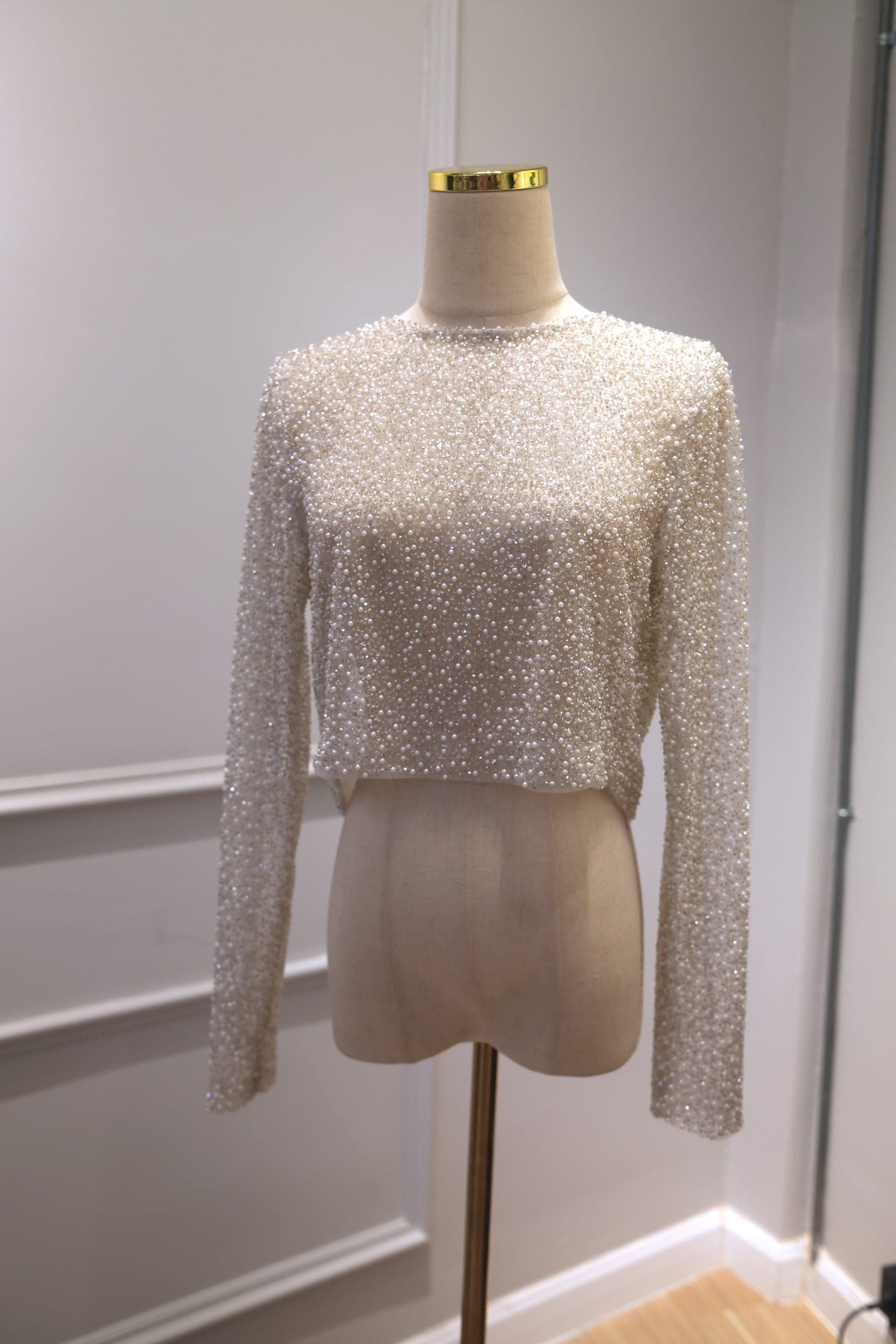 Close-up of a hand-sewn pearl and crystal beaded wedding bodice on a mannequin