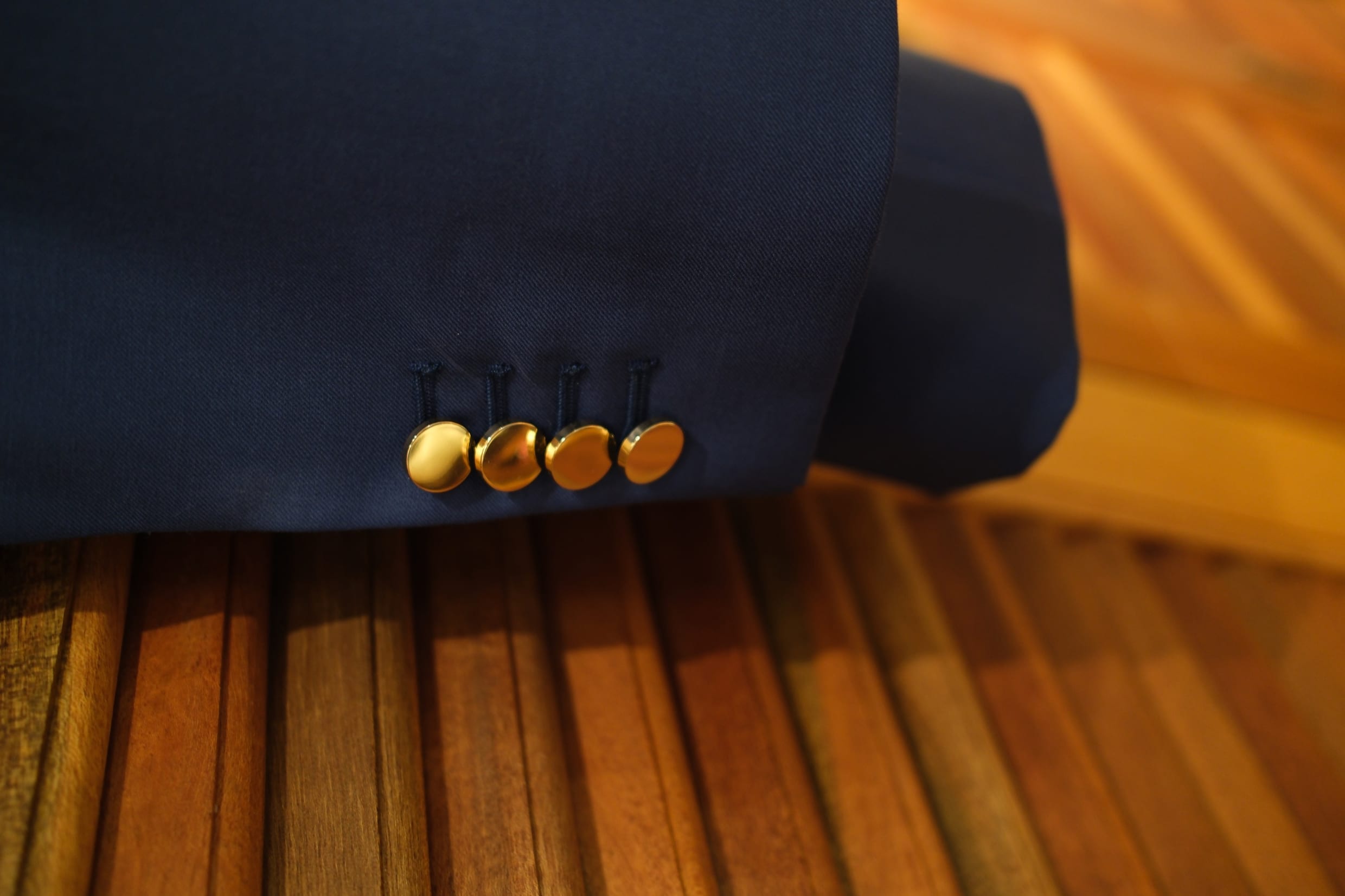 Close-up of gold buttons on the sleeve of a navy women's blazer