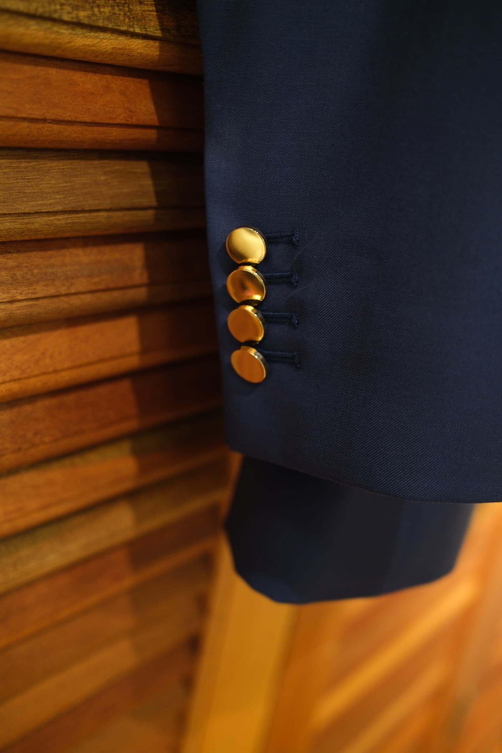 Close-up of gold buttons on the sleeve of a navy women's blazer