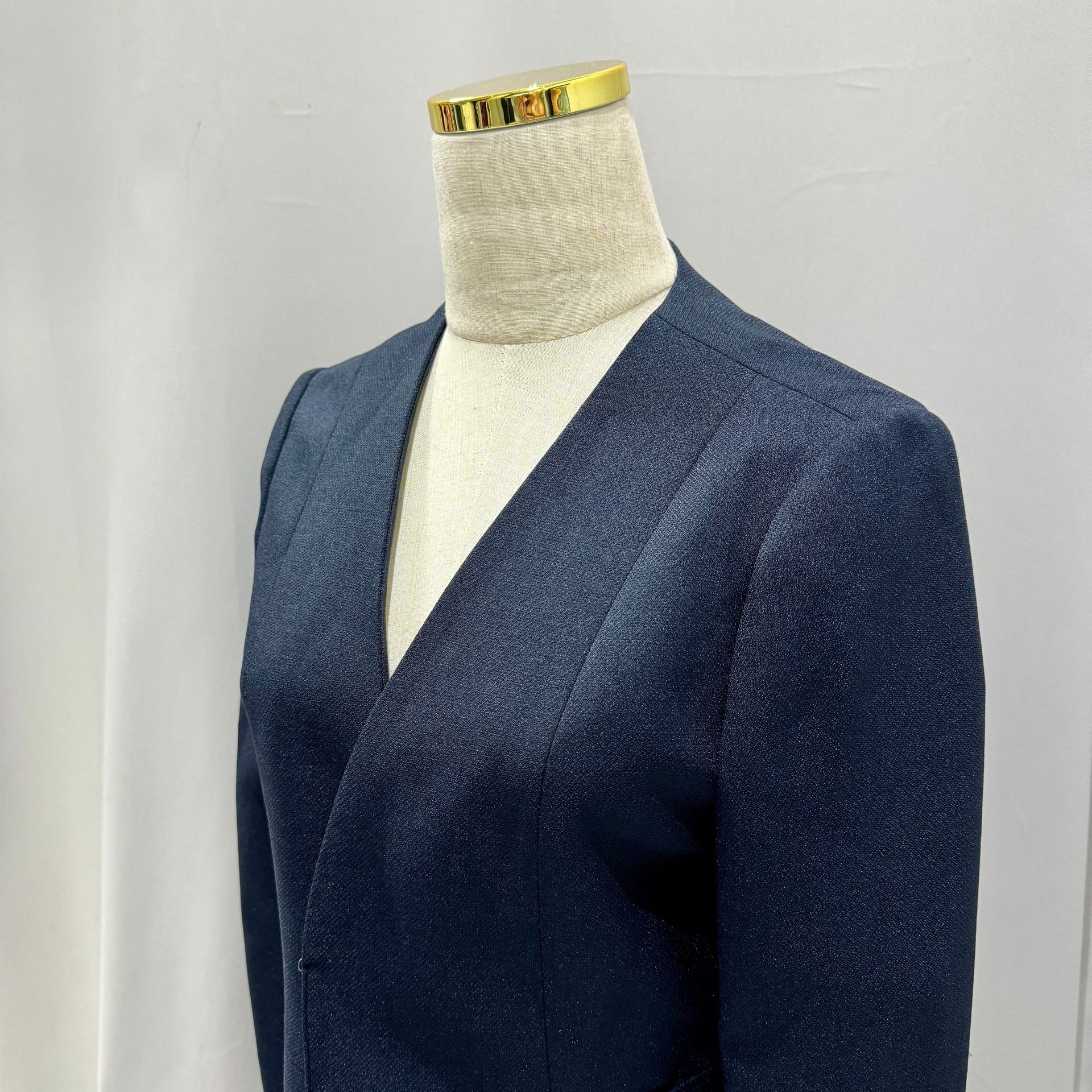 Navy blue wool blazer with V-neck on a mannequin