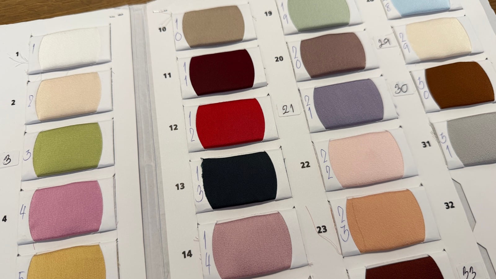 Pearl fabric colour swatch book showing the full range of shades, each numbered
