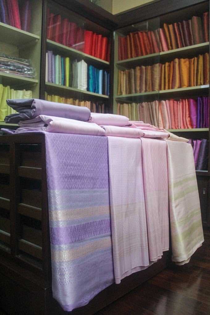 Thai silk brocades draped on a table at Phanthip Thai Silk