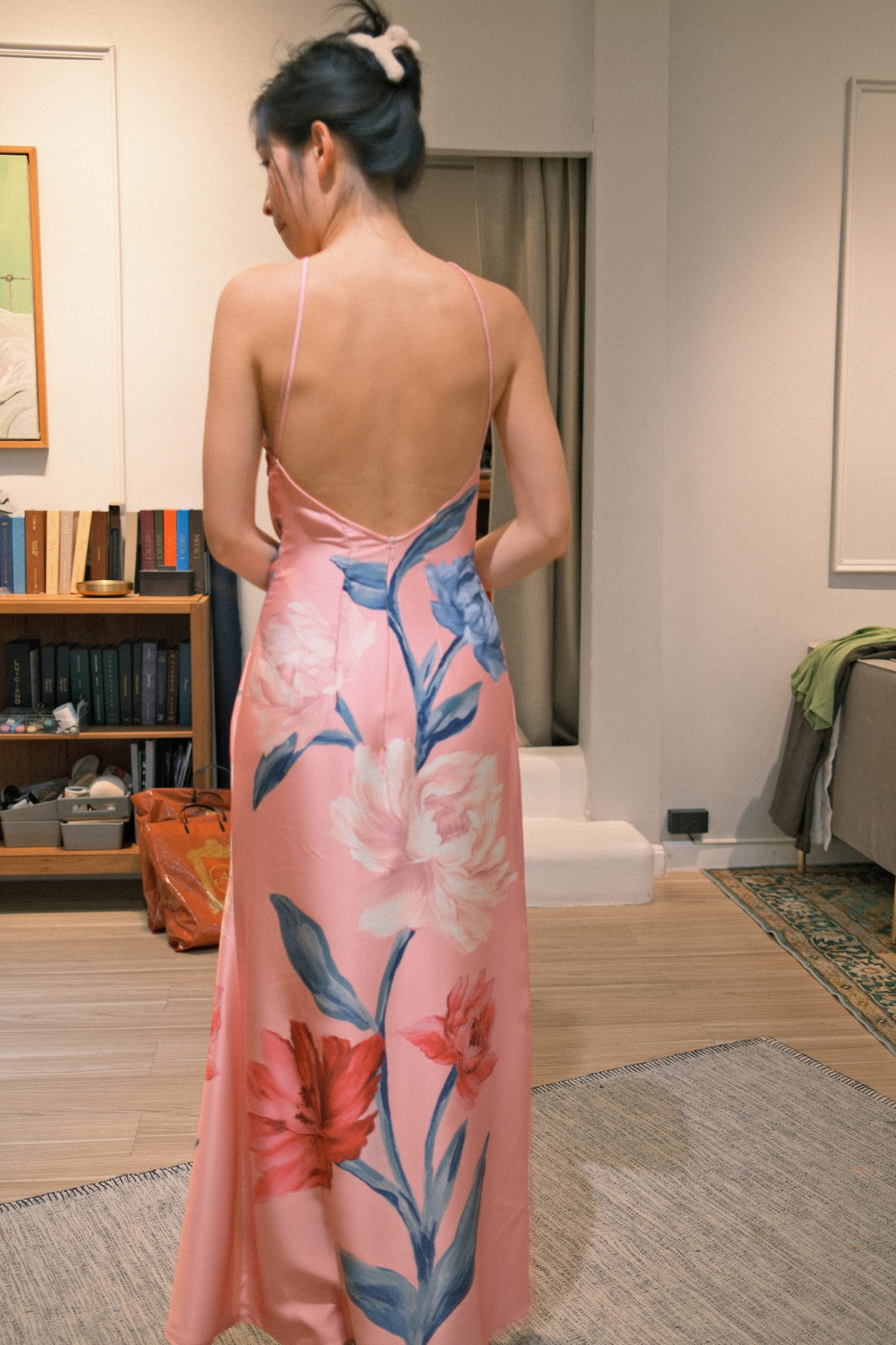Customer wearing a pink floral print silk dress with a backless design