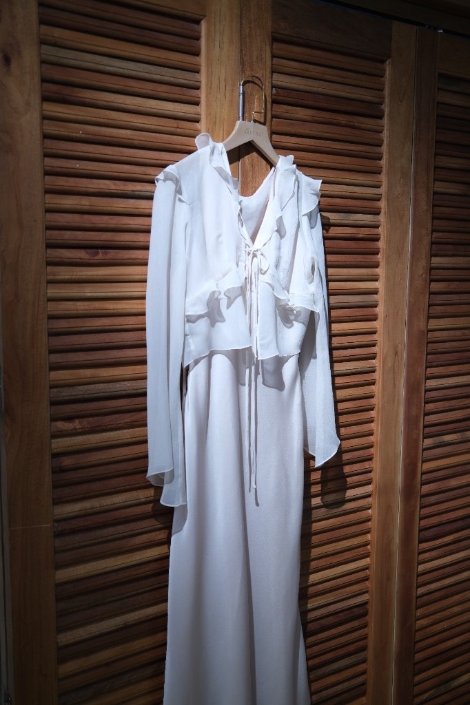 Cream silk kimono-style maxi dress with ruffled neckline on a hanger