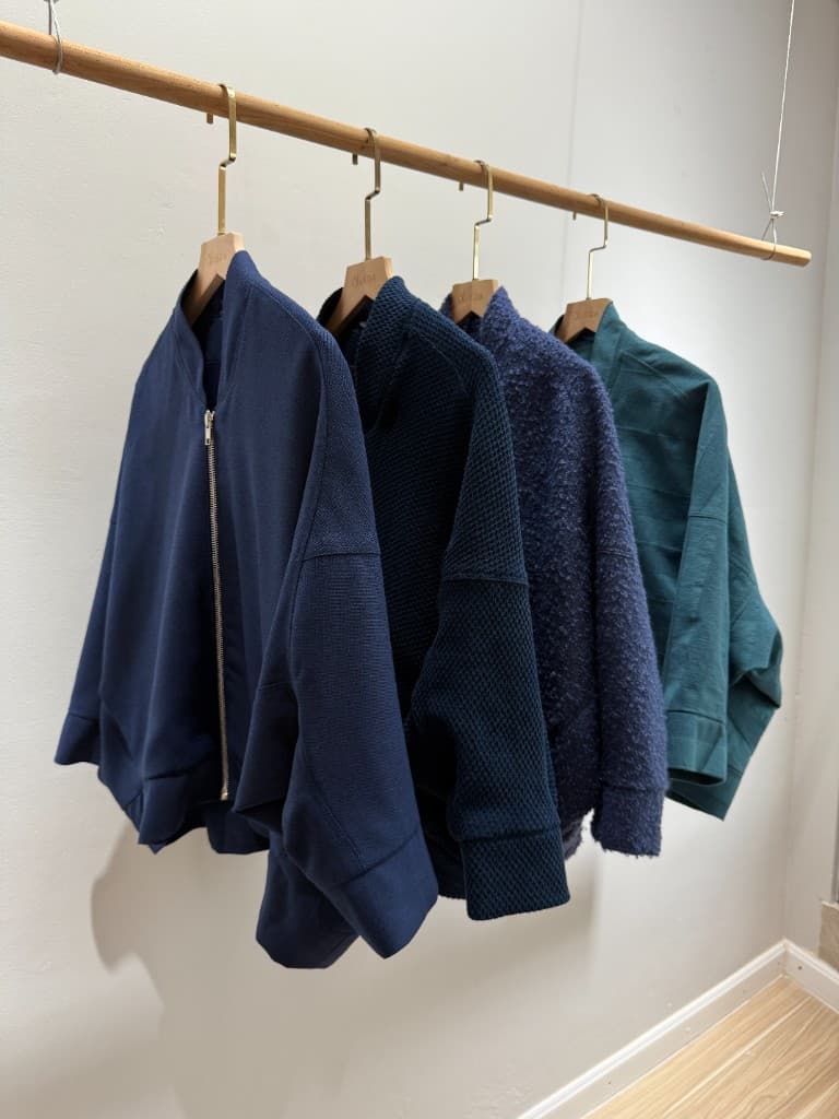 Navy and teal textured jackets on LALEDA hangers