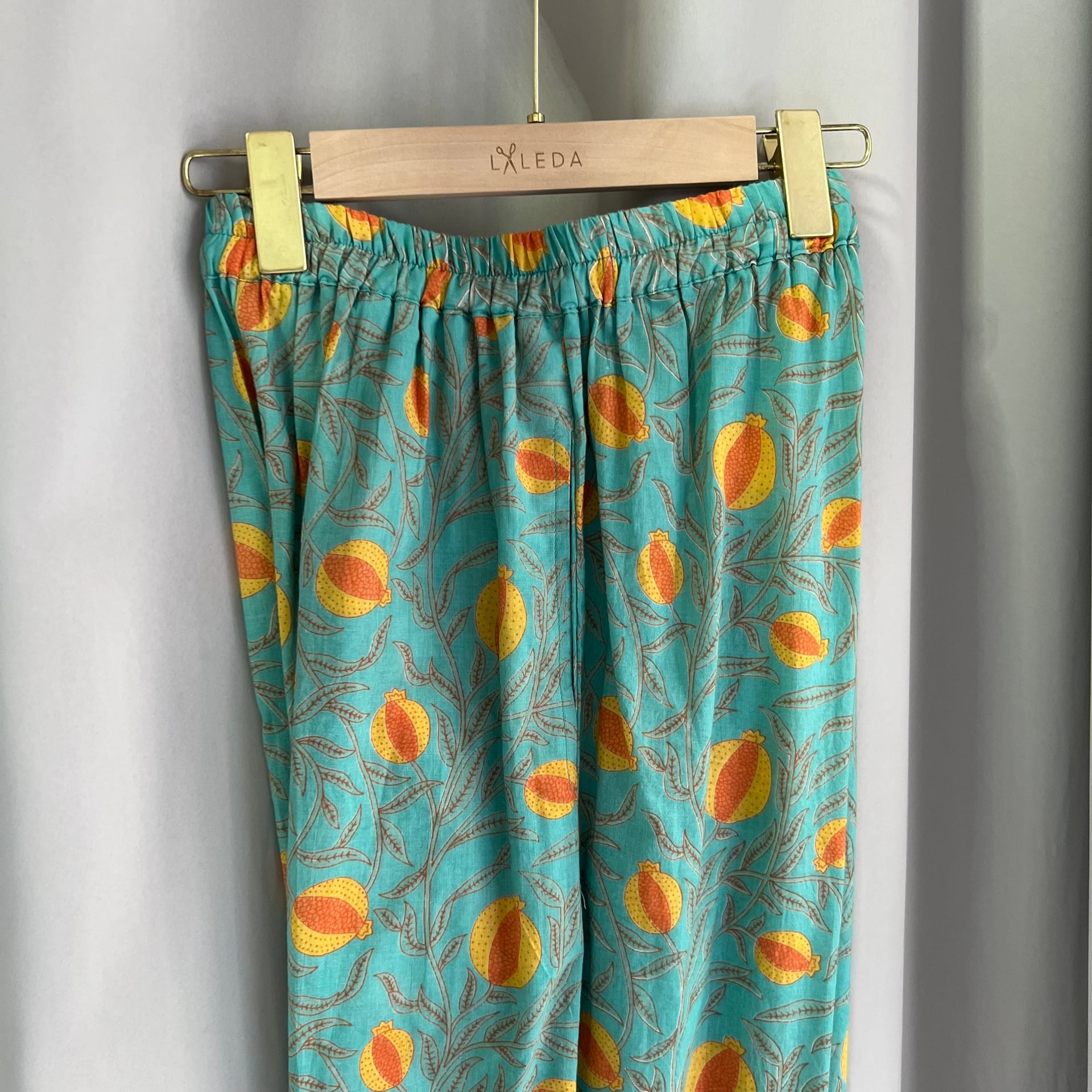 Turquoise citrus print elastic-waist trousers on a LALEDA hanger