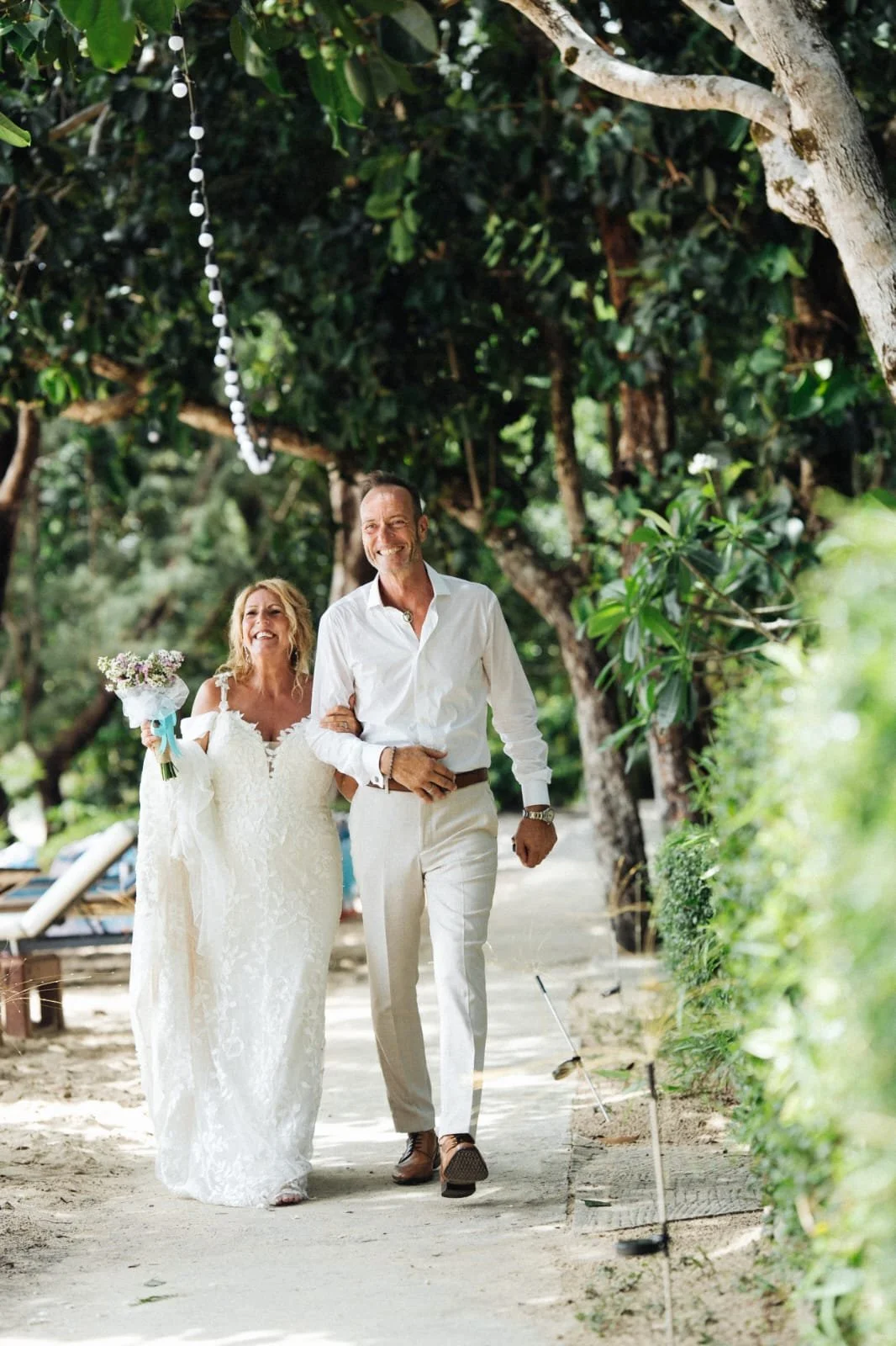 Bride and groom on a beach in a flowing white wedding dress