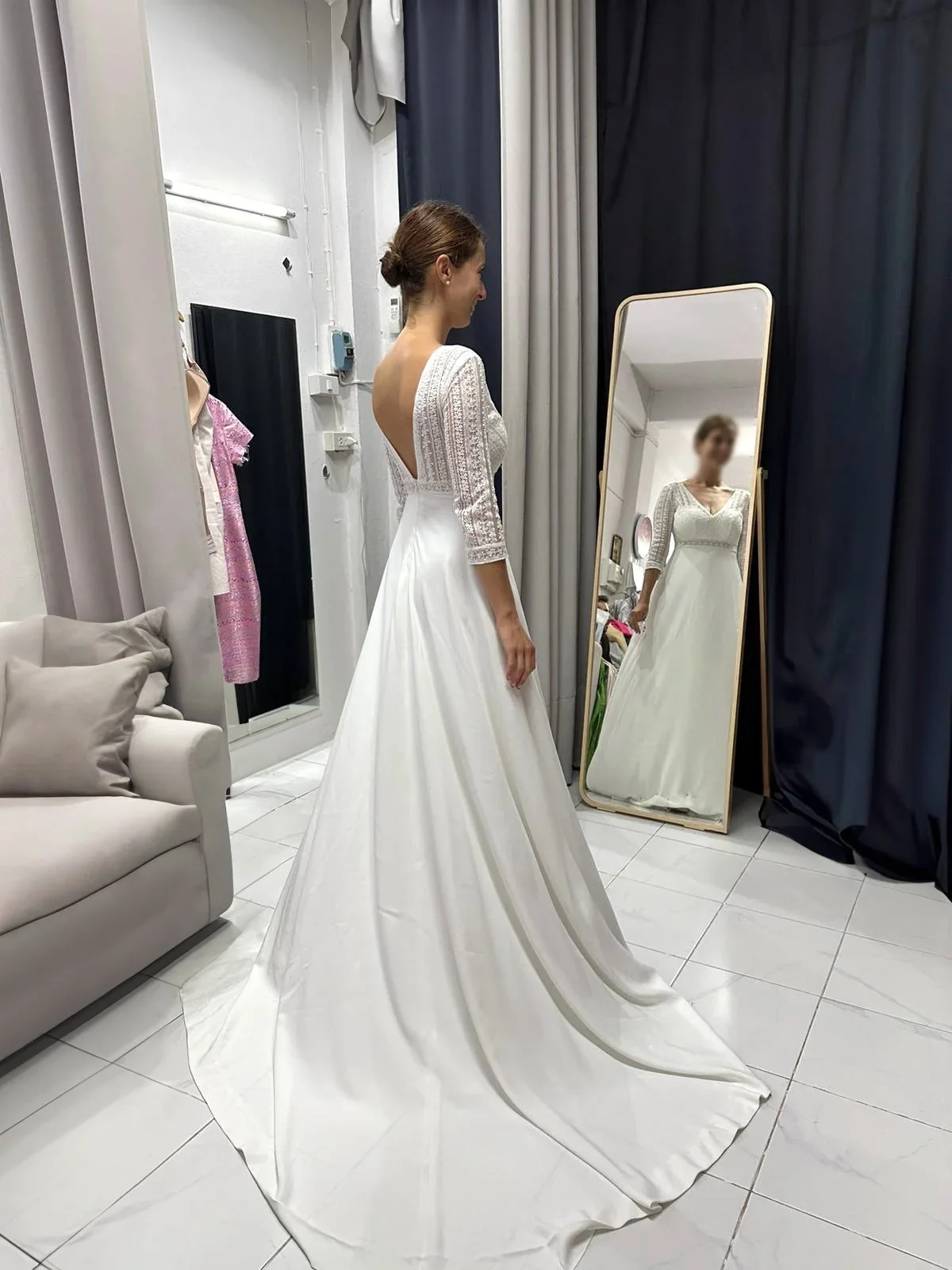 A finished white wedding dress hanging at the LALEDA atelier