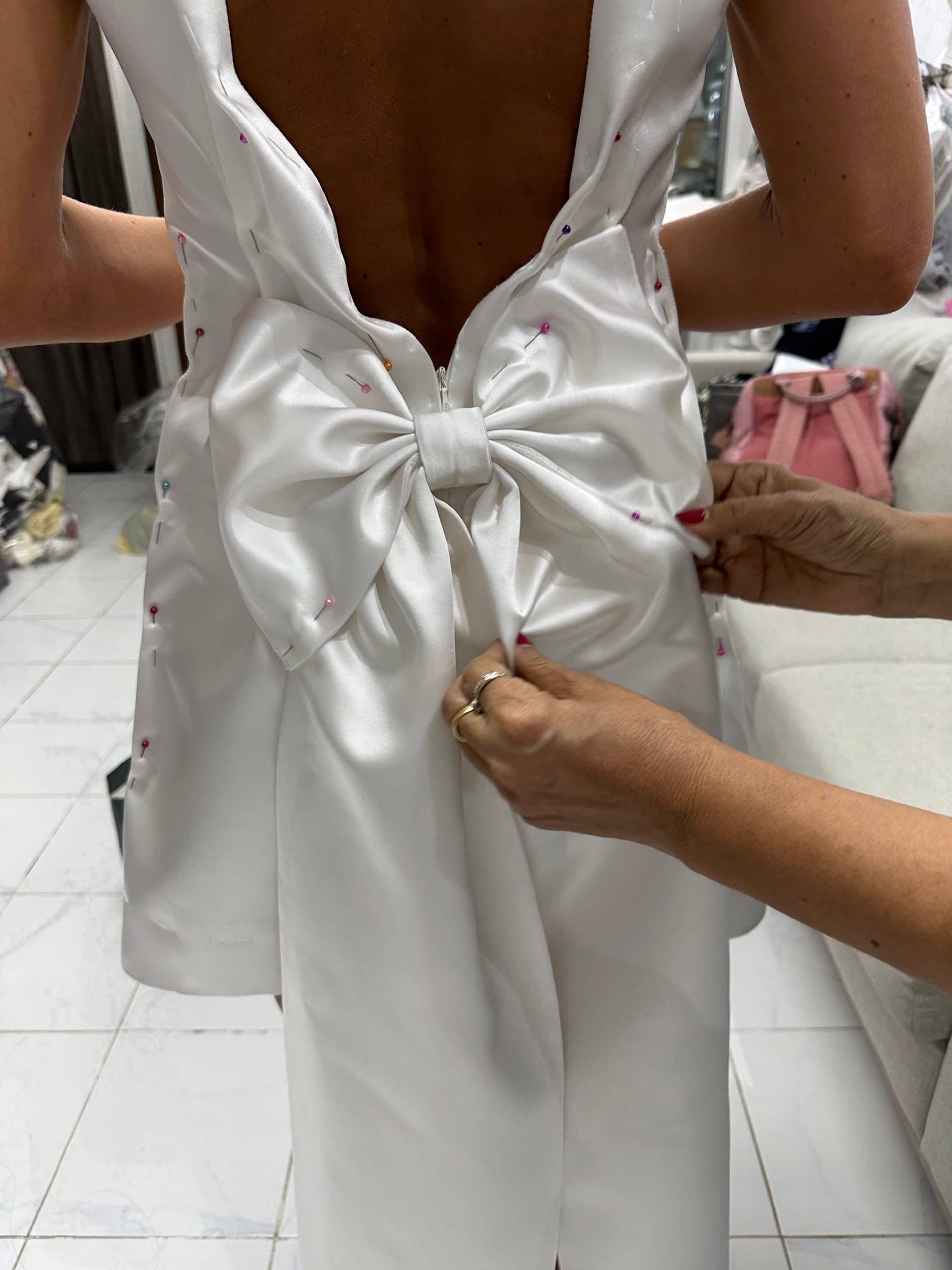 White wedding dress with a bow being fitted