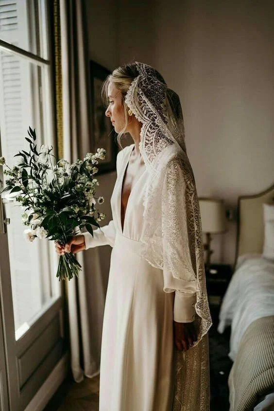 Bride in a traditional white wedding dress with a lace headpiece