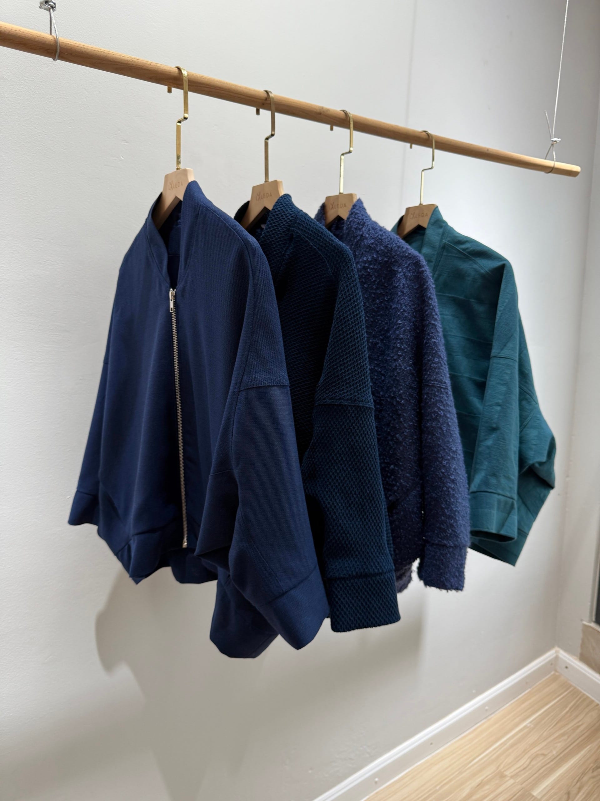 Collection of custom tailored women's blue and teal jackets and tops