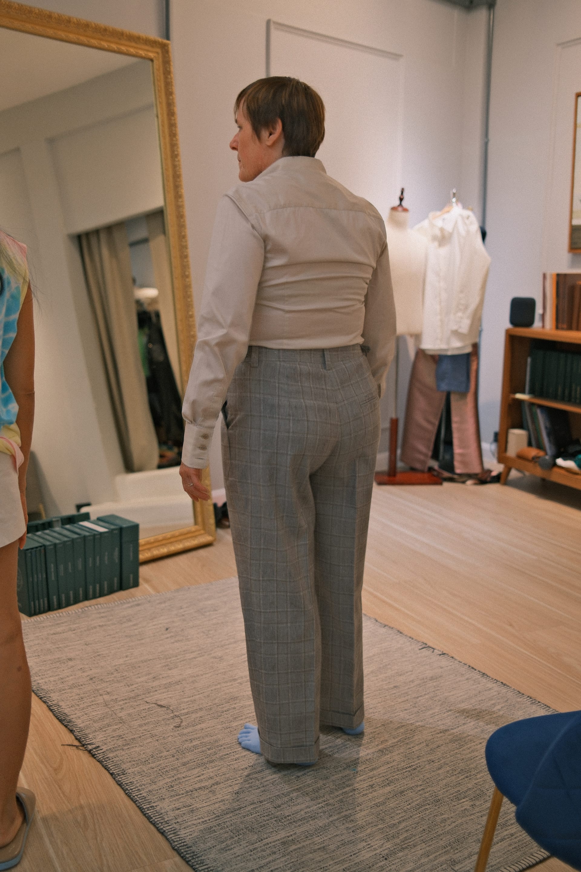 Client wearing grey checked British wool tailored trousers during a fitting